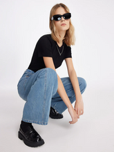 a lady wears a baggy jeans with black T-shirt and loafers